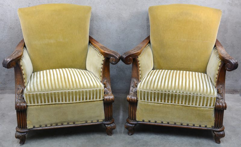 Een paar fauteuils van gesculpteerd eikenhout met olijfgroene bekleding.