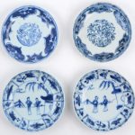 Een kopje met onderbordje en drie andere bordjes van blauw en wit Chinees porselein, waarbij er twee een paar vormen. Tijdperk Qianlong.