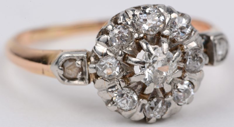 Een 18 karaats wit en geel gouden ring bezet twee diamanten oude slijp en briljanten met een gezamenlijk gewicht van ± 0,50 ct.