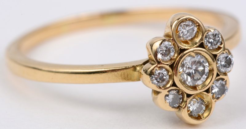Een 18 karaats wit en geel gouden ring bezet twee diamanten oude slijp en briljanten met een gezamenlijk gewicht van ± 0,30 ct.