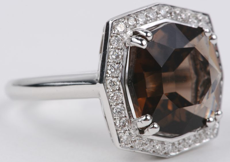 Een 18 karaats wit gouden ring bezet met diamanten met een gezamenlijk gewicht van ± 0,32 ct. en een bruine kwarts van ± 6 ct.