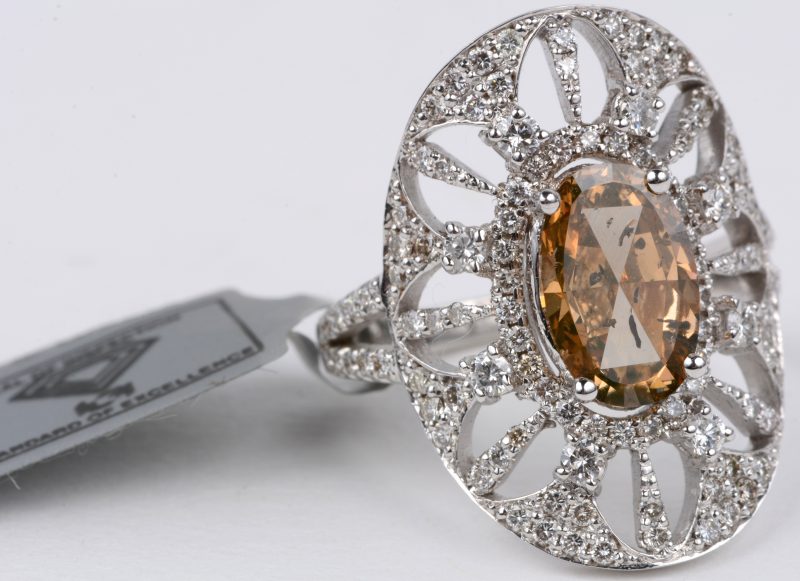 Een 18 karaats wit gouden ring bezet met diamanten met een gezamenlijk gewicht van ± 0,79 ct. en een natural fency diamond van ± 1,47 ct.