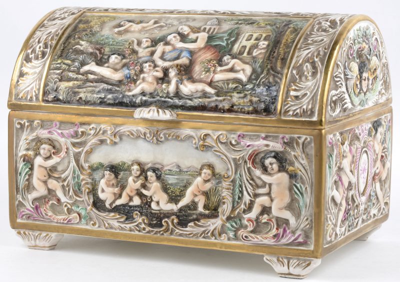 Een koffertje van meerkleurig Italiaans aardewerk in barokke stijl met verscheidene decors in reliëf.
