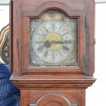 Horloge de vestibule en bois sculpté au cadran en cuivre. XIXe siècle.