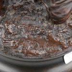 “De roepende waterdrager”. Een beeld van bruingepatineerd brons. Gesigneerd.