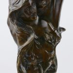 Een paar art nouveau siervazen van gepatineerd brons, versierd met vrouwenhoofden.