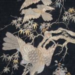 Een antiek Japans wandkleed met vogels en bloemen van goudbrokaat op een zwarte achtergrond. Beschadigingen. XIXe eeuw.