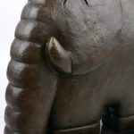 Een gestileerde olifant van bruingepatineerd brons op een marmeren voet.