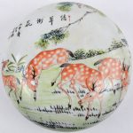 Een Chinese zalfdoos van meerkleurig porselein, versierd met een decor van herten. Onderaan gemerkt.