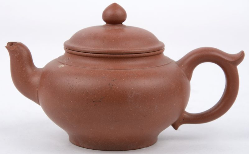 Een theepotje van Chinees terracotta. Onderaan gemerkt. Schilfer aan de tuit en aan de binnenkant van het deksel.
