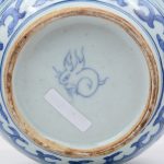Een bolle vaas van Chinees porselein met een blauw en wit deor van Fo-honden.