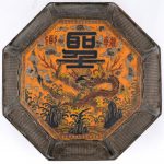 Een achthoekige Chinese dekseldoos van gepolychromeerd hout, het deksel versierd met een draak.