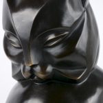Een gestileerde zittende kat van donkergepatineerd brons in art decostijl.