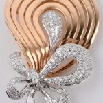 Een parure van 18 karaats wit en rooskleurig goud met hanger, oorbellen en ring bezet met briljanten met een gezamenlijk gewicht van ± 3,10 ct.