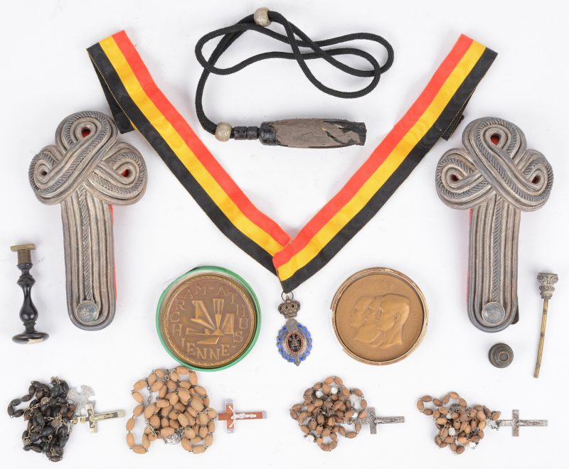 Een lot bestaande uit een Belgische medaille, twee herdenkingsmunten, een aantal paternosters en stempels en militaire schouderkoorden.