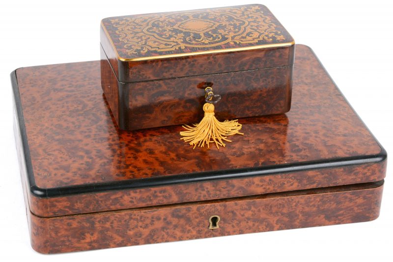 Een grote doos en een kistje met sleutel van wortelfineer, waarbij het tweede met schildpad en messingen inlegwerk op het deksel.