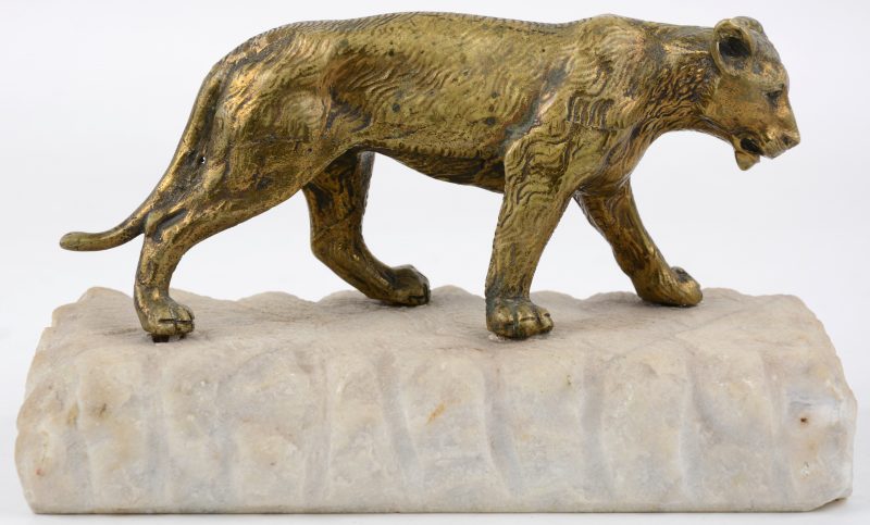 Een leeuwin van goudgepatineerd brons op een natuurstenen sokkel.
