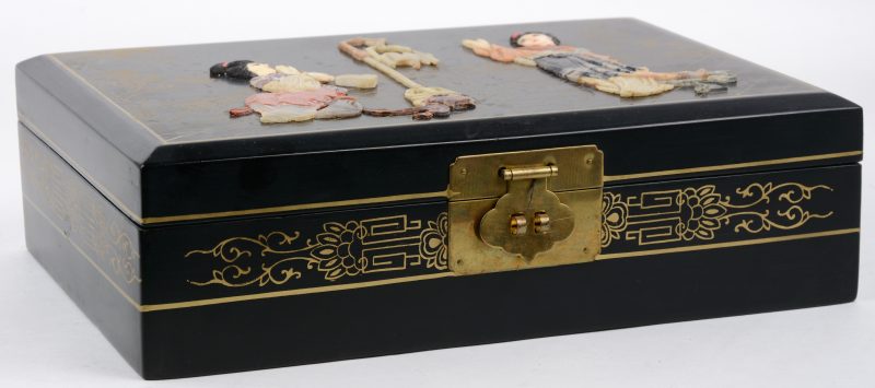 Een Chinese juwelendoos van zwartgelakt hout, versierd met figuren van ivoor en verschillende soorten gesteente.