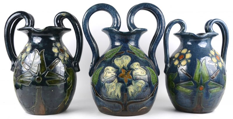 Drie verschillende siervazen vaan meerkleurig Belgisch aardewerk met gestileerde bloemendecors.