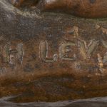 “De mijnwerker”. Een beeld van bruingepatineerd brons op groen marmeren sokkel.