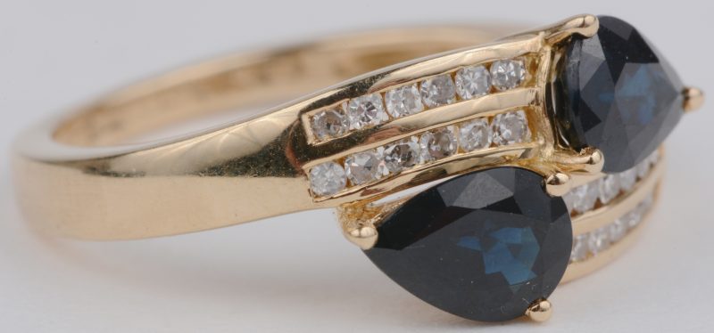 “Toi et Moi”. Een 18 karaats geelgouden ring bezet briljanten met een gezamenlijk gewicht van ± 0,24 ct. en twee saffieren van telkens ± 0,50 ct.