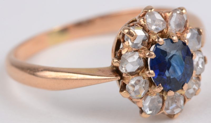 Een 18 karaats geel gouden ring bezet met diamanten oude slijp met een gezamenlijk gewicht van ± 0,40 ct. en een centrale saffier van ± 0,25 ct.