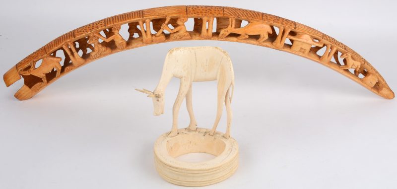 Een slagtand van gesculpteerd ivoor in de vorm van dieren en personages. We voegen er een antiloop van gesculpteerd ivoor aan toe. Afrikaans werk. Eerste helft XXe eeuw.