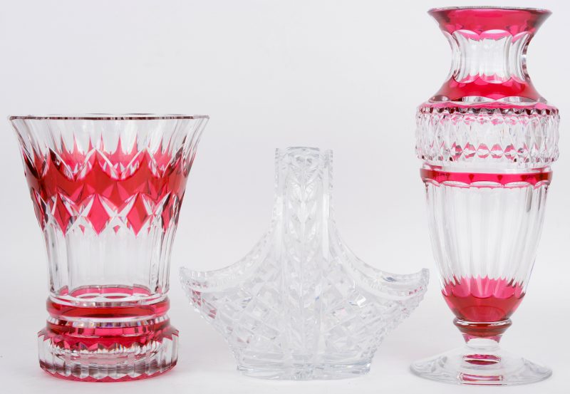 Een lot kristal, bestaande uit twee verschillende vazen van kleurloos en roze kirtsal en een kleurloos geslepen mandje. Eén vaas gemerkt onderaan.