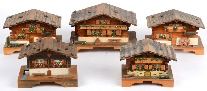 Vijf verschillende miniklokjes in de vorm van Zwitserse huisjes.