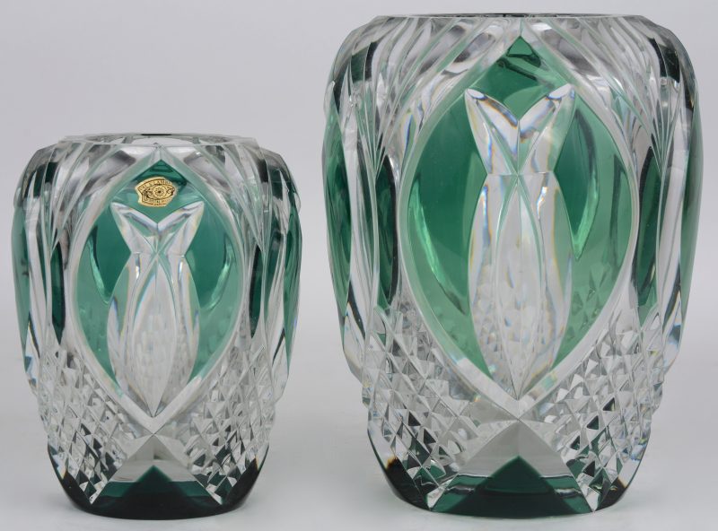 Twee verschillende vazen van geslepen kristal, groen gekleurd in de massa.