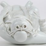 Een Chinees personage van monochroom wit porselein naar het Blanc de Chine. Achteraan gemerkt.