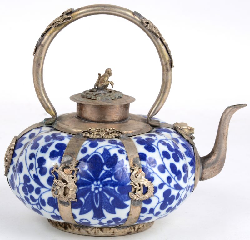 Een pompoenvormig theepotje van Chinees porselein en verzilverd metaal, versierd met een bleuw en wit bloemendecor en met een aapje op het deksel.