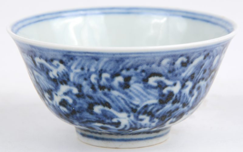 Een waterkommetje van blauw en wit Chinees porselein met Chinese tekens binnenin.