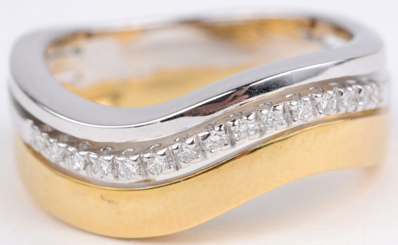 Een 18 karaats wit en geel gouden ring bezet met diamanten met een gezamenlijk gewicht van ± 0,20 ct.