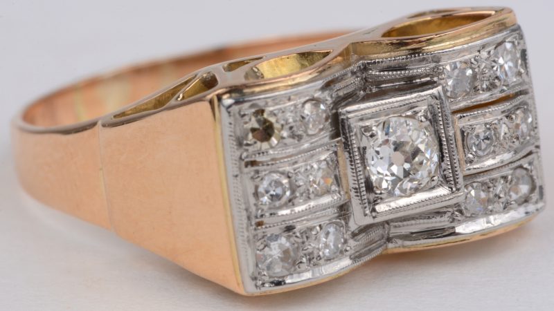 Een 18 karaats wit en geel gouden art deco ring bezet met briljanten met een gezamenlijk gewicht van ± 0,34 ct.