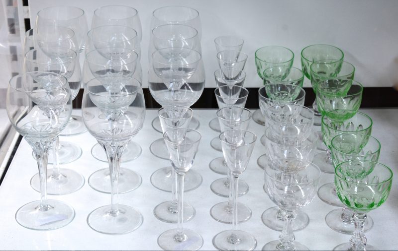 Een lot kristallen glazen, bestaande uit elf wijnglazen, acht hoge borreltjes en twaalf aperitiefglazen, waarvan acht groene.
