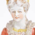 Een jonge vrouw en heer in XVIIIe eeuwse klederdracht van meerkleurig porselein. Onderaan gemerkt.