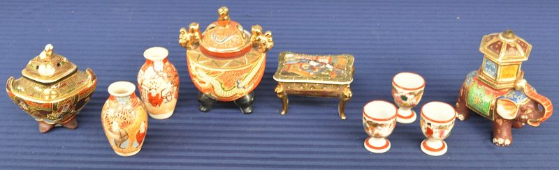Een lot Satsuma-aardewerk, bestaande uit twee kleine vaasjes, twee koro’s, een juwelendoosje en een lampvoetje in de vorm van een olifant.We voegen er drie eierdopjes aan toe.