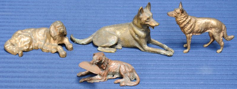 Een lot van vier bronzen hondjes, waarbij één als onderdeel van een asbak en één als inktpot.