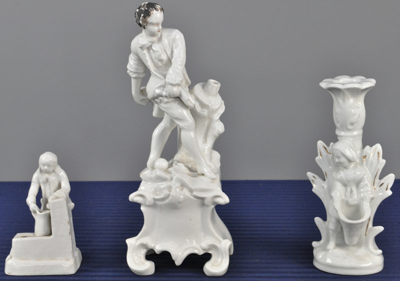 Een lot wit porselein, bestaande uit een man bij een waterpomp, een man met een bal en een kandelaar met een vrouw met een mand.
