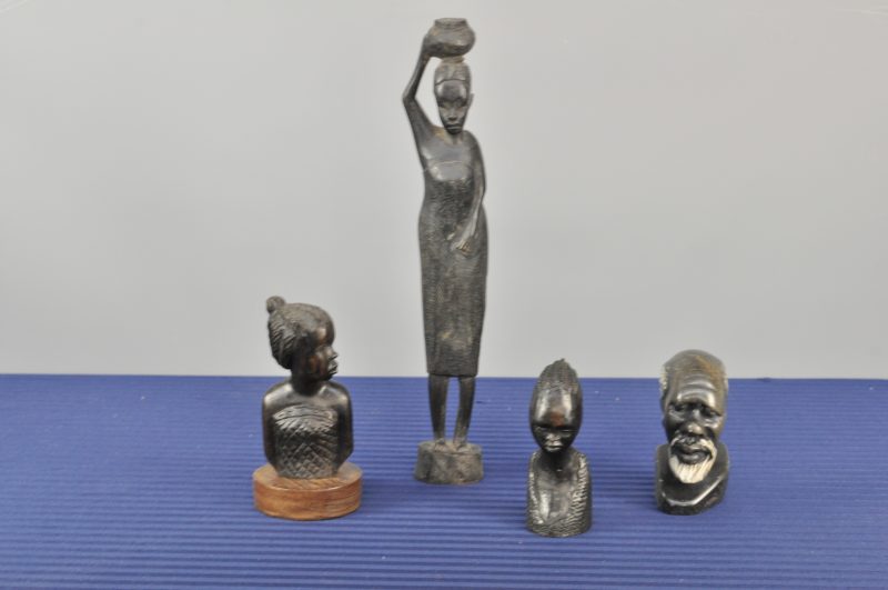 Een lot van twee bustes en een beeldje van gesculpteerd Afrikaans hout. We voegen er een Afrikaanse mannenbuste van gesculpteerd steen aan toe.