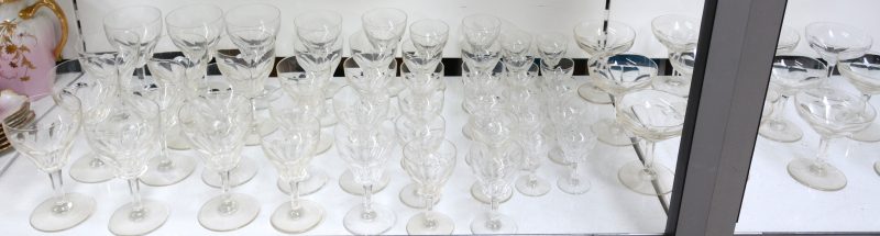 Een glasservies van geslepen kleurloos kristal, bestaande uit elf borrelglaasjes, twaalf aperitiefglazen, twaalf champagnecoupes, tien wittewijnglazen en twaalf rodewijnglazen.