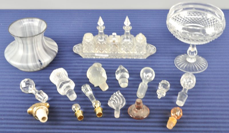 Een lot kristal en glas, bestaande uit een coupe op voet, een tafelsetje, veertien verschillende stoppen van karaffen en een vaasje van glaspasta.