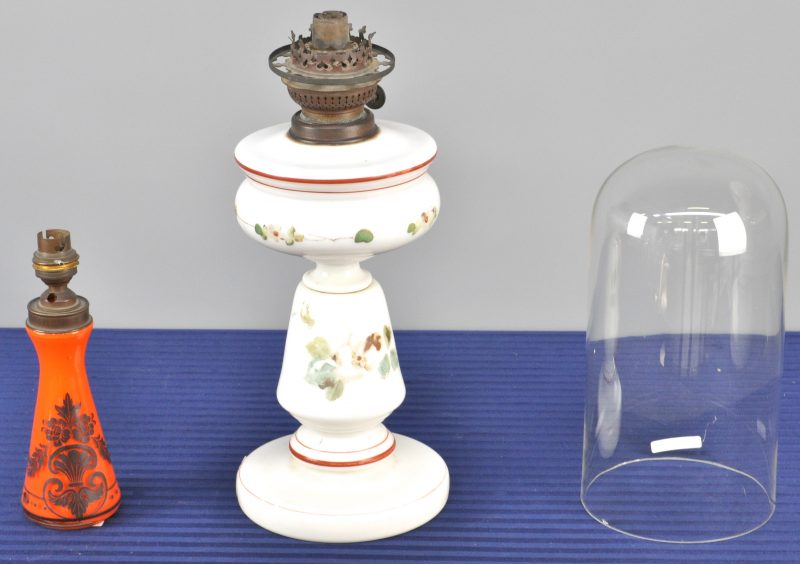 Een lot glas, bestaande uit een lampje van oranje glas, een olielamp van opaalglas en een stolp.