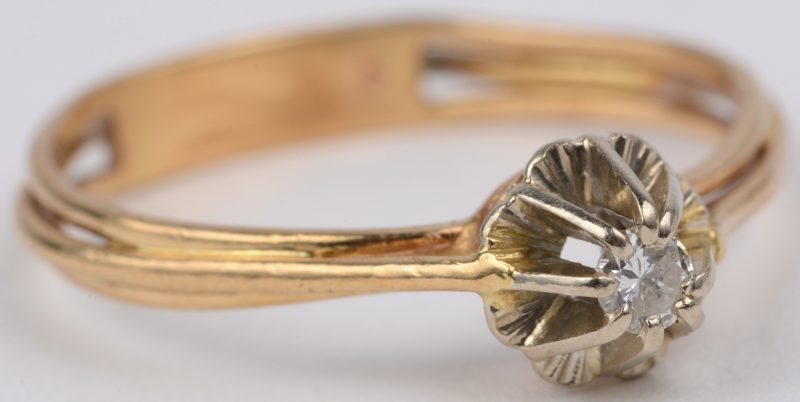Een 18 karaats wit en geel gouden ring bezet met één briljant van ± 0,10 ct.