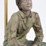 Een polychroom bronzen beeld van een zittende jonge man gemonteerd als lamp. Getekend en gestempeld.