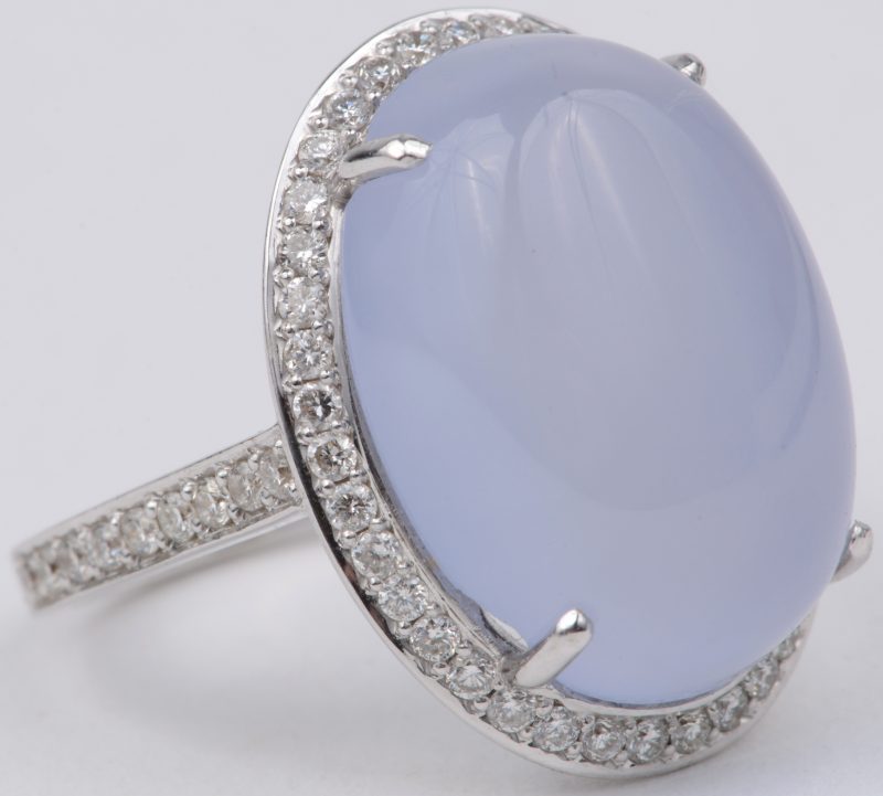 Een 18 karaats wit gouden ring bezet met diamanten met een gezamenlijk gewicht van ± 0,65 ct. en een calcedoon van ± 16,70 ct.