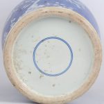 Een vaas van Chinees porselein met een wit decor van bloesems op een blauwe achtergrond.