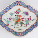 Een schaal op voet van meerkleurig Chinees porselein met een decor van personages op een fabeldier. Onderaan gemerkt.