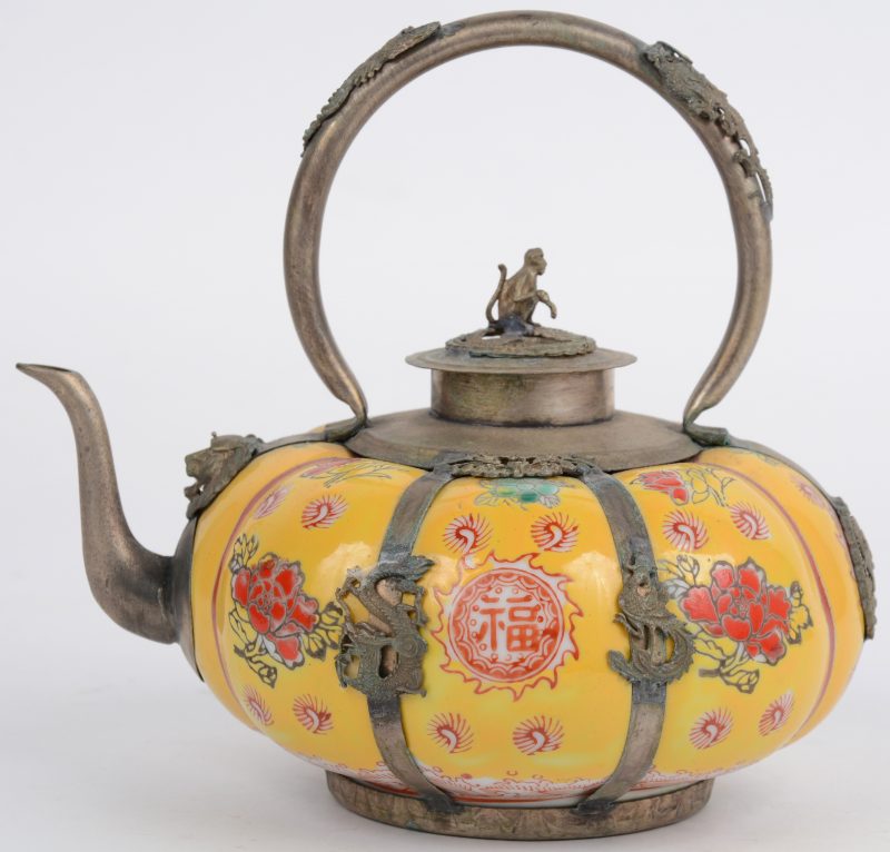 Een pompoenvormig theepotje van Chinees porselein met zilveren monturen en een meerkleurig decor van bloemen op gele fond. Het deksel getooid met een aapje op een draak.